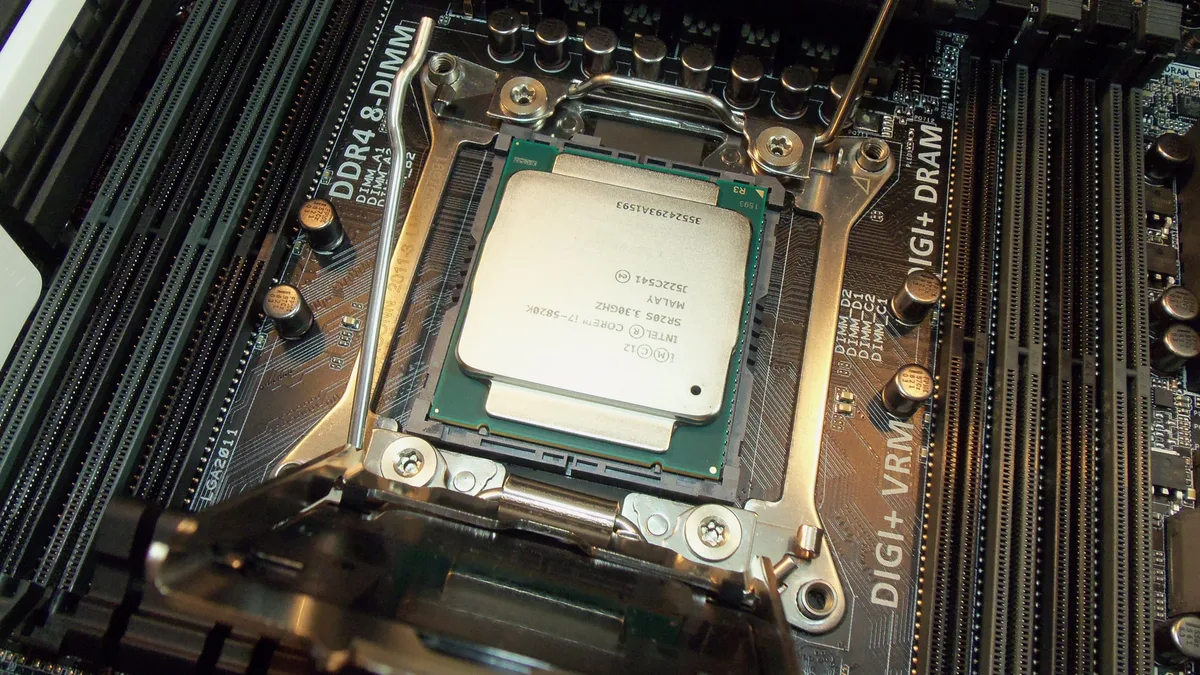 A processor being fitted into the socket of a desktop motherboard during a gaming PC build